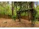 Backyard features a charming wooden swing, a fence and natural surroundings at 4709 Knights Arm Dr, Durham, NC 27707