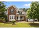 This home features brick and vinyl siding, a front porch, an attached garage, and manicured landscaping at 4709 Knights Arm Dr, Durham, NC 27707