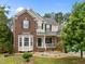 Charming two-story home with a brick and siding exterior, a well-manicured lawn, and a welcoming front porch at 4709 Knights Arm Dr, Durham, NC 27707
