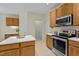Kitchen with stainless appliances, wood cabinets, island and view to the laundry room at 4709 Knights Arm Dr, Durham, NC 27707
