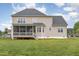 Spacious backyard with a deck, screened porch, and green grass leading up to the house at 4905 Homestead Dr, Mebane, NC 27302
