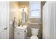 Clean bathroom with a white vanity, toilet, framed mirror, and shower with a curtain, illuminated by stylish lighting at 4905 Homestead Dr, Mebane, NC 27302