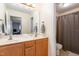 Bright bathroom with a double vanity, large mirror, and a shower with patterned curtain at 4905 Homestead Dr, Mebane, NC 27302