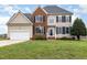 Charming two-story home features a brick facade, black shutters, and a well-manicured lawn at 4905 Homestead Dr, Mebane, NC 27302
