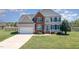 Inviting two-story home with a well-maintained lawn and a charming picket fence in the background at 4905 Homestead Dr, Mebane, NC 27302