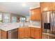 Well-appointed kitchen features a stainless steel refrigerator, dishwasher, and double basin sink with a bright backsplash at 4905 Homestead Dr, Mebane, NC 27302