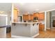 Charming kitchen featuring warm-toned cabinets, breakfast bar, and modern appliances, seamlessly connecting to the entryway at 4905 Homestead Dr, Mebane, NC 27302