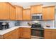 Modern kitchen with stainless steel appliances, light countertops, ample wood cabinetry, and stylish tile backsplash at 4905 Homestead Dr, Mebane, NC 27302