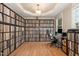 Home office featuring hardwood flooring, built-in shelving units, a tray ceiling, and a comfortable work space at 4905 Homestead Dr, Mebane, NC 27302