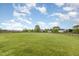Large grassy yard, partially fenced in, under a blue sky with clouds at 4905 Homestead Dr, Mebane, NC 27302