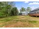 Large, grassy backyard with mature trees and a spacious deck at 508 N Charles St, Mebane, NC 27302