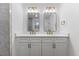 Bathroom featuring double sink vanity, white cabinets, quartz countertop and dual mirrors with modern lighting at 508 N Charles St, Mebane, NC 27302