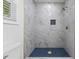 Beautiful shower with marble-style tile, blue mosaic floor, and gold hardware at 508 N Charles St, Mebane, NC 27302