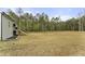 Lawn and wooded backyard with stairs to patio and garden, offering privacy and a connection with nature at 52 Sagebrook Ct, Zebulon, NC 27597