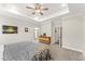 Spacious primary bedroom with tray ceiling, carpet floors, and ensuite bathroom at 52 Sagebrook Ct, Zebulon, NC 27597