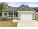 Charming home featuring a covered porch, two-car garage, and nicely landscaped front yard at 52 Sagebrook Ct, Zebulon, NC 27597