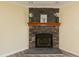 Close up of a stone fireplace with wooden mantle and decorative floral arrangements at 660 Our Way, Linden, NC 28356