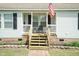 Inviting front porch with white railings, seating, and an American flag waving proudly at 660 Our Way, Linden, NC 28356