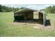 Outdoor metal storage shelter with dirt floor on grassy property at 660 Our Way, Linden, NC 28356