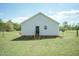 View of the home's rear exterior with vinyl siding and a simple black door at 660 Our Way, Linden, NC 28356