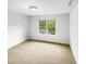 Spacious bedroom with neutral carpet, a large window with backyard view, and ample space at 7 Moonbeam Ct, Durham, NC 27712