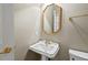 Traditional half-bathroom features pedestal sink, octagonal mirror and gold hardware at 7002 Old Trail Dr, Durham, NC 27712