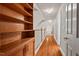 Bright hallway featuring hardwood floors, a built-in bookshelf, and a staircase leading to the upper level at 7002 Old Trail Dr, Durham, NC 27712