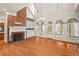 Bright living room with hardwood floors, a fireplace, and French doors leading to outdoor space at 7002 Old Trail Dr, Durham, NC 27712