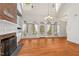 Bright living room featuring high ceiling, large windows, fireplace, and hardwood flooring at 7002 Old Trail Dr, Durham, NC 27712