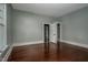 Bedroom with hardwood floors, neutral walls, and a closet; adjacent room in view at 703 Cokey Rd, Rocky Mount, NC 27801