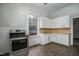 Well-lit kitchen featuring modern appliances, laminate flooring, and white cabinets at 703 Cokey Rd, Rocky Mount, NC 27801