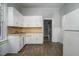 Kitchen boasts white cabinets, laminate flooring, and ample counter space at 703 Cokey Rd, Rocky Mount, NC 27801
