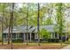 Charming single-story home with gray siding, black shutters, and lush trees at 706 Kensington Dr, Chapel Hill, NC 27514