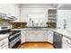Well-lit kitchen with white cabinetry, stylish backsplash, and modern stainless steel appliances at 706 Kensington Dr, Chapel Hill, NC 27514