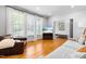 Living room featuring hardwood floors, a comfortable couch, and large windows providing natural light at 706 Kensington Dr, Chapel Hill, NC 27514
