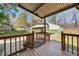 Back deck with wooden railings overlooking backyard, trees, and two carports at 711 Melanie St, Durham, NC 27704