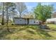 Lush backyard with picnic table, swing set, and convenient carport with shed, perfect for outdoor activities at 711 Melanie St, Durham, NC 27704