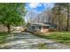 Quaint brick home with blue shutters, green lawn, and an expansive driveway for ample parking at 711 Melanie St, Durham, NC 27704