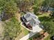 Birds eye view of a spacious backyard and winding driveway, set amongst lush greenery at 7336 Barham Hollow Dr, Wake Forest, NC 27587
