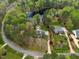 Aerial view of a residential neighborhood with mature trees, lawns, and a lake nearby at 7336 Barham Hollow Dr, Wake Forest, NC 27587