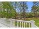 Scenic view of the tranquil pond with seating, viewed from a porch with classic white railings at 7336 Barham Hollow Dr, Wake Forest, NC 27587