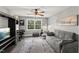 Cozy bedroom featuring a comfortable gray sofa, a ceiling fan, and natural light from a window at 7336 Barham Hollow Dr, Wake Forest, NC 27587