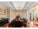 Formal dining room with hardwood floors, coffered ceiling, chandelier, and adjacent seating area at 7336 Barham Hollow Dr, Wake Forest, NC 27587
