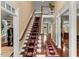 Elegant foyer with hardwood floors, staircase with patterned carpet, and wainscoting detail at 7336 Barham Hollow Dr, Wake Forest, NC 27587