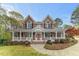 Beautiful two-story brick home with a welcoming front porch and manicured landscaping at 7336 Barham Hollow Dr, Wake Forest, NC 27587