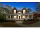 Charming brick home with a welcoming front porch, decorative columns, and mature landscaping at 7336 Barham Hollow Dr, Wake Forest, NC 27587