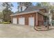 Attached three-car garage with brick exterior, offering ample parking and storage space at 7336 Barham Hollow Dr, Wake Forest, NC 27587
