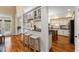 Spacious kitchen featuring white cabinetry, granite countertops, island with seating, and hardwood floors at 7336 Barham Hollow Dr, Wake Forest, NC 27587