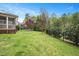 Expansive backyard features lush green grass and mature trees surrounded by a black metal fence at 800 Laurel Garden Way, Cary, NC 27513
