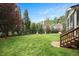 Large backyard features a manicured lawn, mature trees, and a charming wood fence at 800 Laurel Garden Way, Cary, NC 27513
